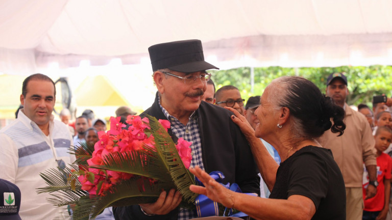 Danilo Medina es recibido, de manera efusiva y con ramo de flores, por Reyna Sánchez durante Visita Sorpresa a Castillo, Duarte. 