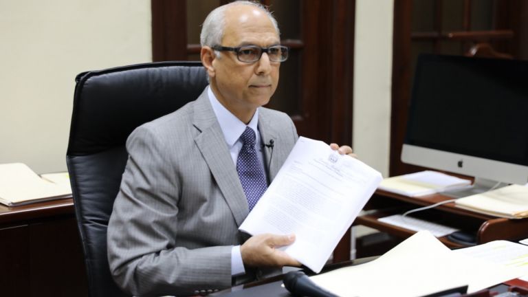 Flavio Darío Espinal, consultor jurídico del Poder Ejecutivo, muestra informes entregados al Congreso Nacional